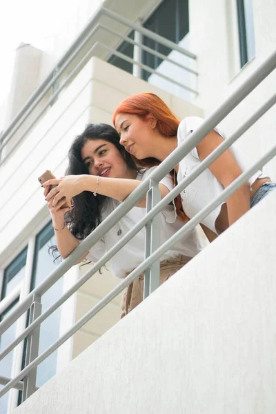 Plan Vertical Deux Amies Regardant Téléphone Debout Sur Balcon — Photo