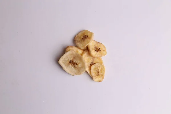 An overhead shot of nutritious dried banana chips deliciously arranged on a gray table