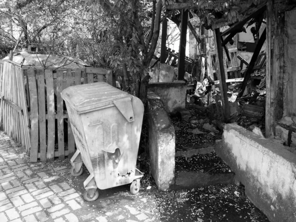 Tiro Escala Cinza Uma Lata Lixo Frente Ruínas Edifícios Antigos — Fotografia de Stock