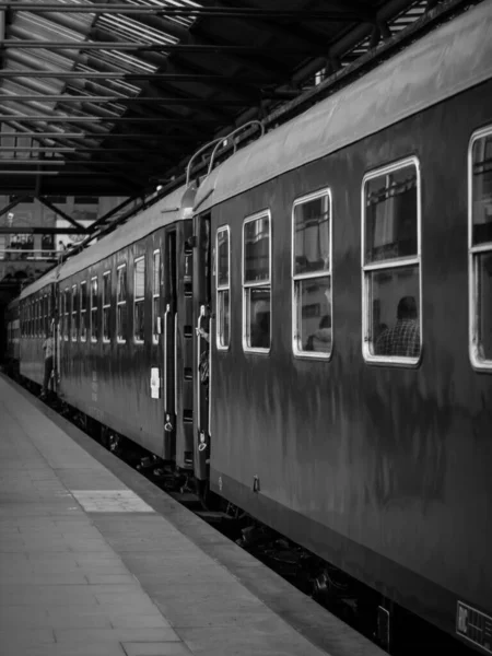 屋内駅での列車の垂直グレースケールショット — ストック写真