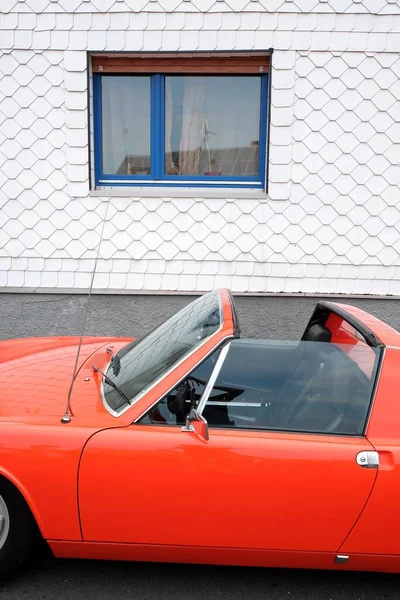 1970年代のドイツのミッドエンジンスポーツ車で オレンジレッドの折り畳み式ヘッドライトが付いています — ストック写真