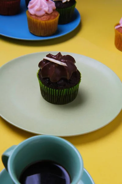 Colpo Verticale Cupcake Cioccolato Piatto Grigio Una Superficie Gialla Con — Foto Stock