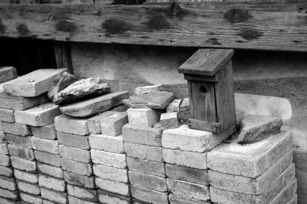 Graustufenaufnahme Eines Hölzernen Vogelhauses Auf Ziegelsteinen Auf Einer Baustelle — Stockfoto