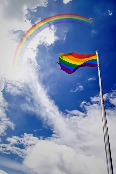 Vertikal Bild Regnbågsflagga Som Viftar Vinden Blå Molnig Himmel Med — Stockfoto