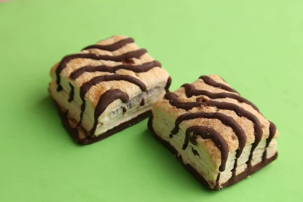 緑色の背景に2つのおいしい甘いチョコレートトッピングクッキー — ストック写真