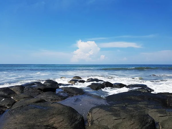 Uma Praia Rochosa Mar Ondulado Sob Céu Azul Nuvens Brancas — Fotografia de Stock