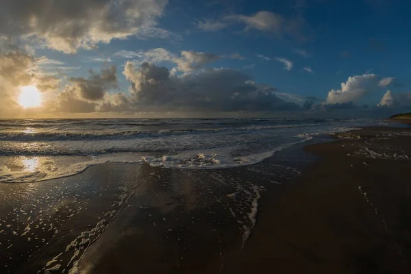 Een Strand Omringd Door Zee Onder Een Blauwe Bewolkte Hemel — Stockfoto