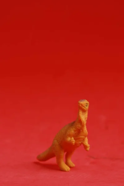 Tiro Vertical Brinquedo Dinossauro Plástico Isolado Fundo Vermelho — Fotografia de Stock