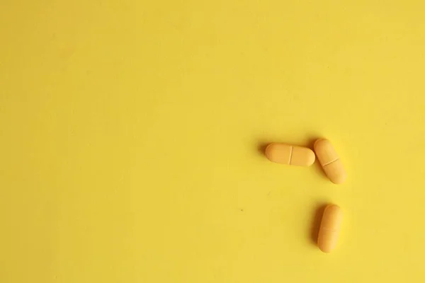 黄色の表面に黄色の錠剤のクローズアップショット — ストック写真