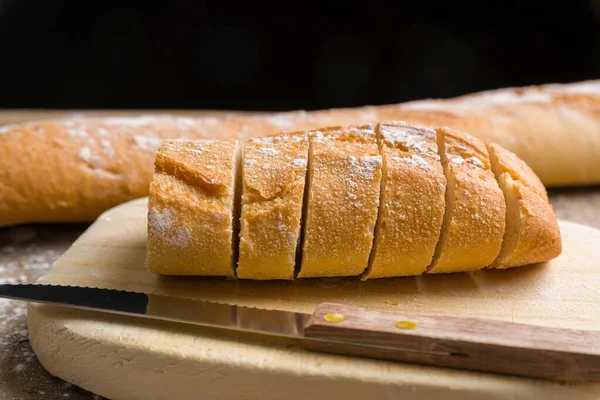 Närbild Ett Franskt Bröd Skivor Och Kniv Placerad Träskiva — Stockfoto