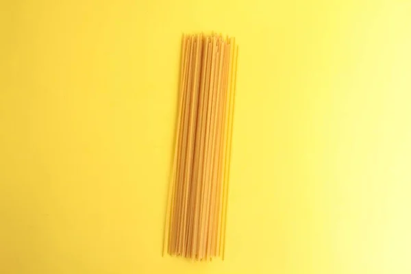 黄色の背景に生スパゲティの高い角度のクローズアップショット — ストック写真