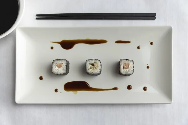 Una Vista Superior Tres Rollos Sushi Plato Con Palillos Mesa —  Fotos de Stock