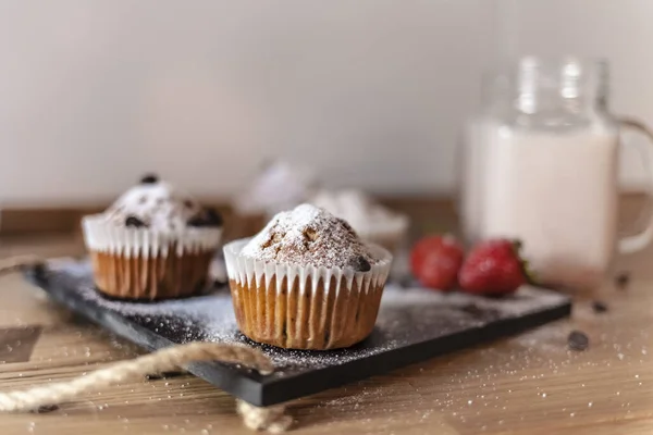 Primo Piano Cupcake Con Piccoli Pezzi Cioccolato Zucchero Polvere Tavolo — Foto Stock