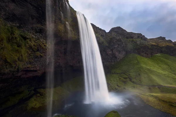 冰岛美丽的塞尔贾兰多斯瀑布从青苔丛生的悬崖上滑落下来 拍到了一张低角的照片 — 图库照片