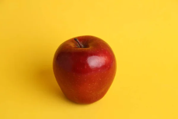 Ein Roter Apfel Auf Gelber Oberfläche — Stockfoto