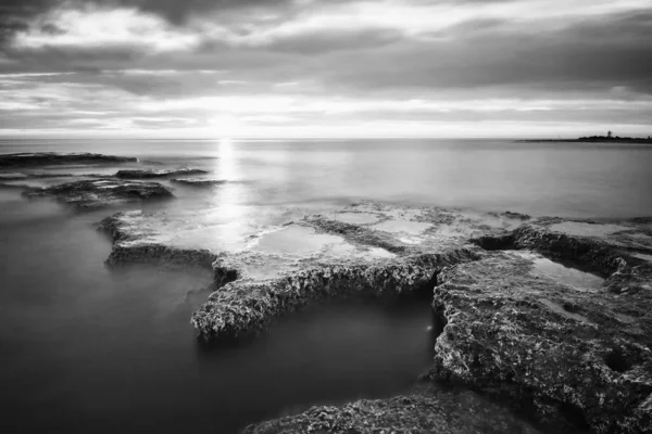 Grayscale Shot Rocks Water Cloudy Day — Stock Photo, Image