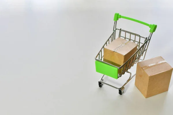 A small shopping cart with boxes on a white background - online shopping concept