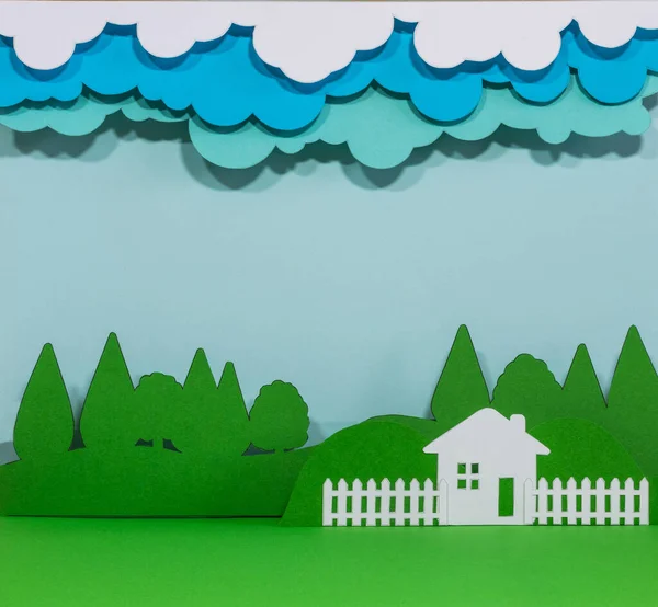 森林附近有栅栏和云彩的房子的纸制雕像 — 图库照片