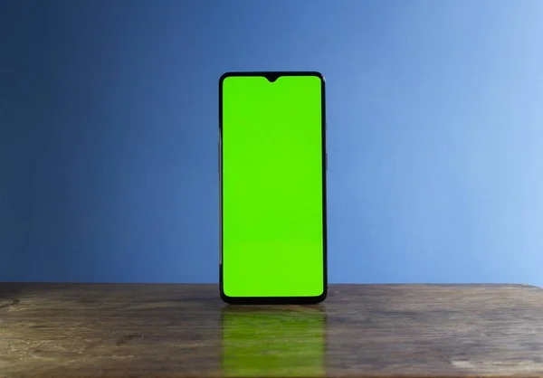 A closeup shot of a cellular phone on a wooden table