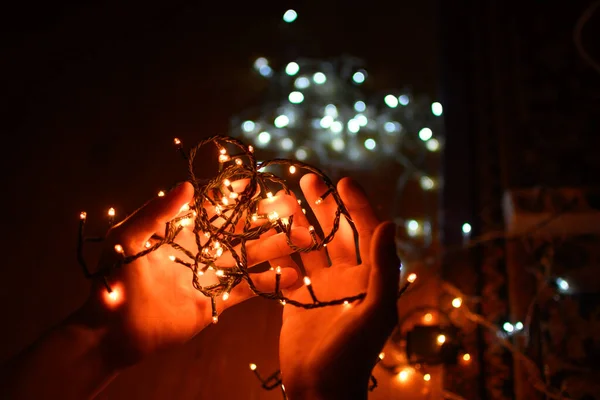 暗闇の中でクリスマスの装飾ライトを持っている人 — ストック写真