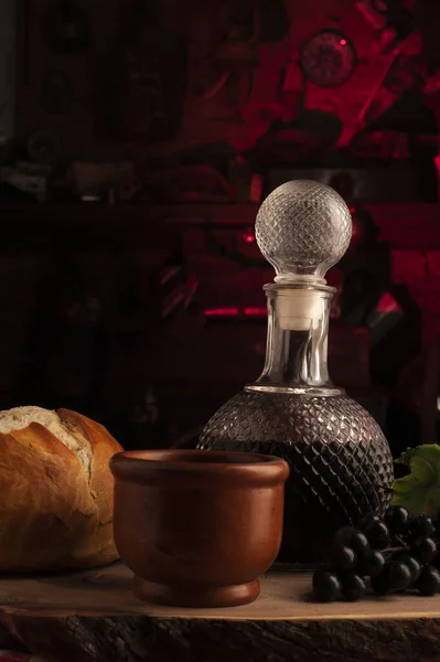 stock image A beautiful vertical shot of a glass decanter with bread and pottery mug on the side