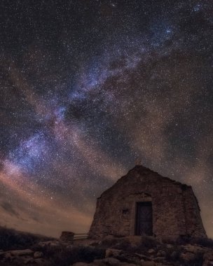 An amazing low angle vertical shot of a chapel on top of Island Vis in Croatia under the milky way galaxy night sky clipart
