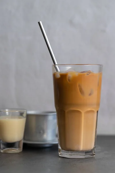 背景是越南冰镇咖啡与浓缩牛奶和越南咖啡滤清器的垂直镜头 — 图库照片