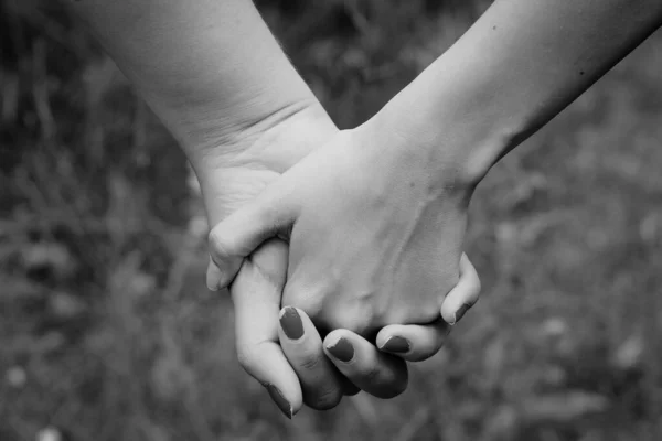 手を握っているカップルの灰色のスケールの浅い焦点ショット — ストック写真
