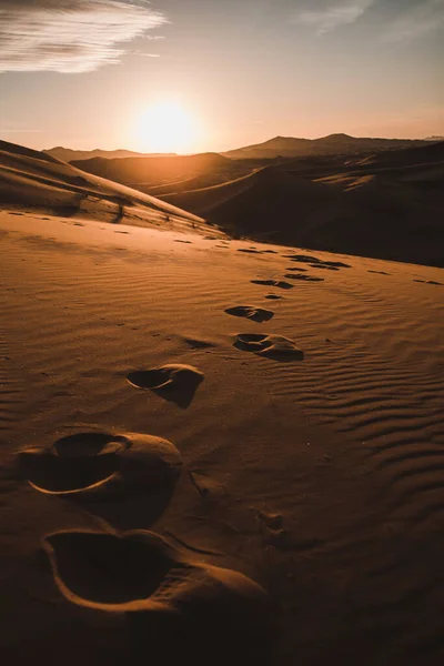Een Verticaal Shot Van Voetafdrukken Een Woestijn Met Zandduinen Bij — Stockfoto
