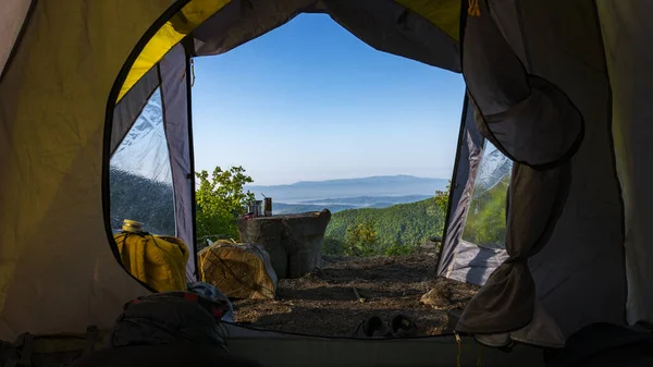 A panoramic view of the mountains taken from inside a camping tent