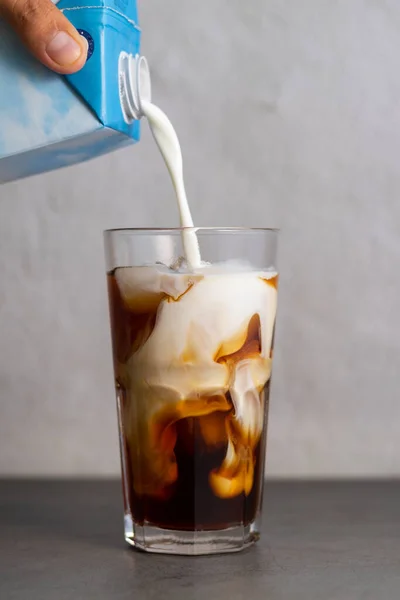 Вертикальный Снимок Человека Наливающего Молоко Стакан Холодного Кофе — стоковое фото