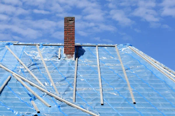 Крупный План Крыши Дома Покрытого Голубыми Пластиковыми Пакетами — стоковое фото