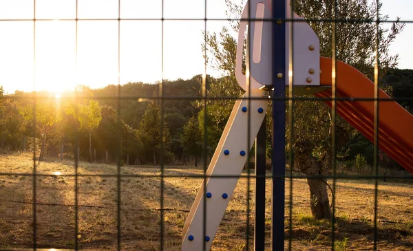 Parco Giochi Soleggiato Visto Attraverso Una Rete Metallica — Foto Stock