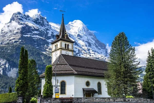 位于瑞士格林德沃德的一座背景上有雪山的教堂的美丽表演 — 图库照片