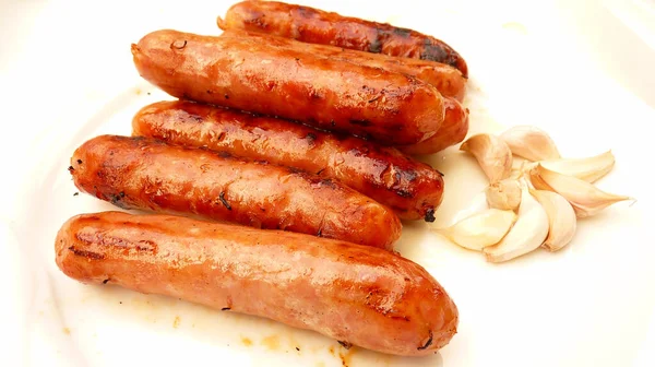 Eine Nahaufnahme Von Grillwürsten Mit Knoblauch Auf Einem Weißen Teller — Stockfoto