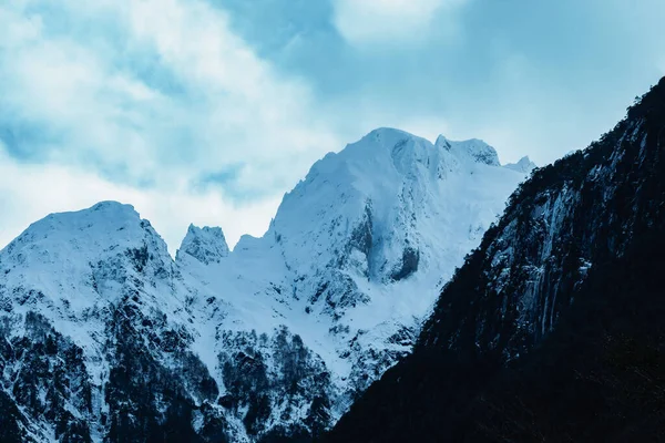 在多云的天空下 美丽的白雪覆盖的山峰的低角镜头 — 图库照片