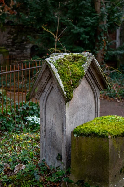 Ein Vertikaler Blick Auf Einen Bemoosten Grabstein Auf Einem Friedhof — Stockfoto