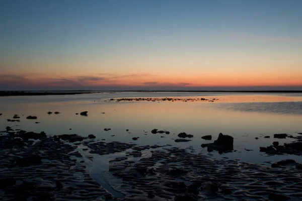 美丽的夕阳西下沙滩上的大石头 — 图库照片