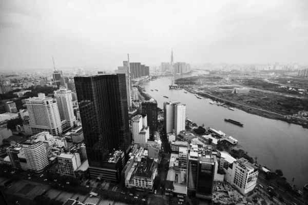 霧の日に川や高層ビルがあるベトナムのホーチミン市の航空グレースケールのショット — ストック写真