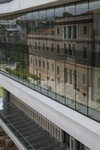 レンガ造りの建物を反映した現代的なガラスの建物の垂直ショット — ストック写真