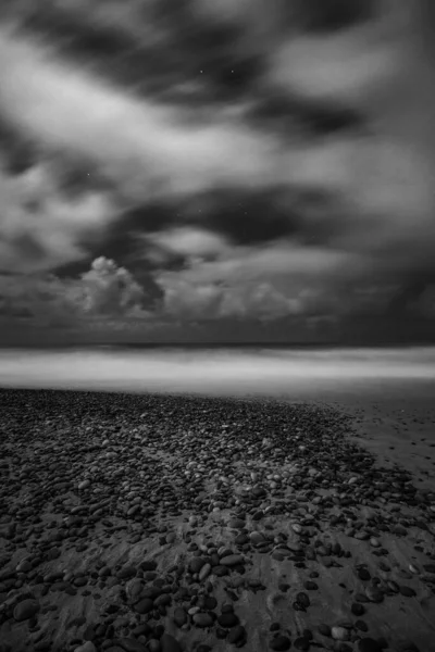 Koyu Bulutlu Gökyüzünün Altında Denizin Gövdesine Çakıl Taşlarının Dikey Bir — Stok fotoğraf