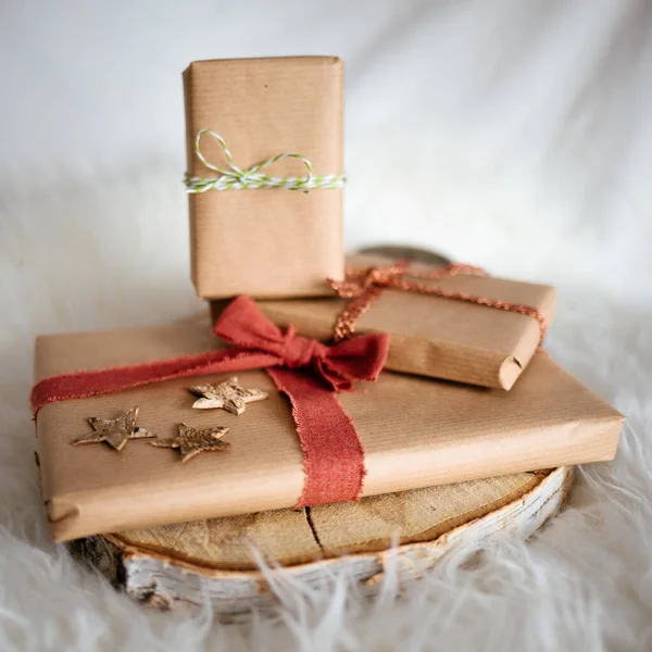 用手工纸包在一块木头上的礼物和缎带做成的特写 — 图库照片