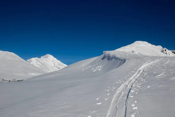 Una Vetta Ricoperta Neve Bianca Pulita Con Tracce — Foto Stock