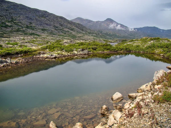 Sebuah Kolam Kecil Yang Dikelilingi Oleh Pegunungan Dan Hijau Bawah — Stok Foto