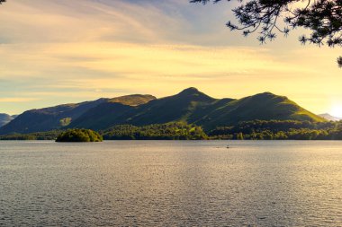 A sunlit Derwentwater lake surface with a greeny mountain range behind at vibrant sunset clipart