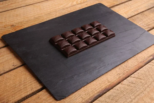 Una Barra Chocolate Sobre Una Superficie Madera Negra — Foto de Stock