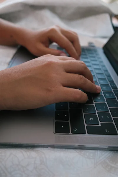 ラップトップキーボードを使用して男性の手の垂直ショット — ストック写真