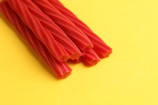 Closeup Red Long Twisted Candy Yellow Background — Stock Photo, Image