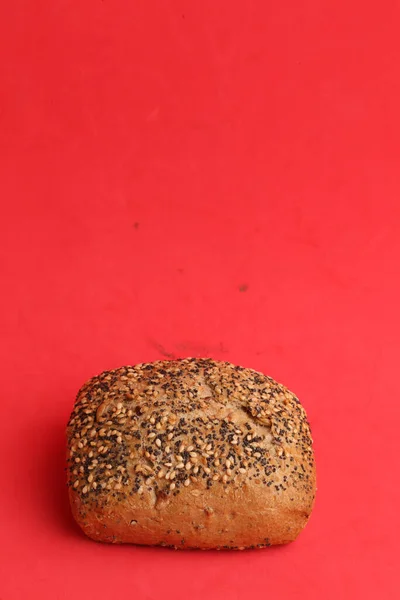 Vertical Shot Seeded Bread Roll Red Background — Stock Photo, Image