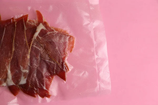Una Fetta Carne Cruda Una Confezione Sottovuoto Una Superficie Rosa — Foto Stock